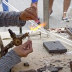 Soffiatore di vetro al lavoro a Murano, mentre plasma la sabbia con il fuoco.