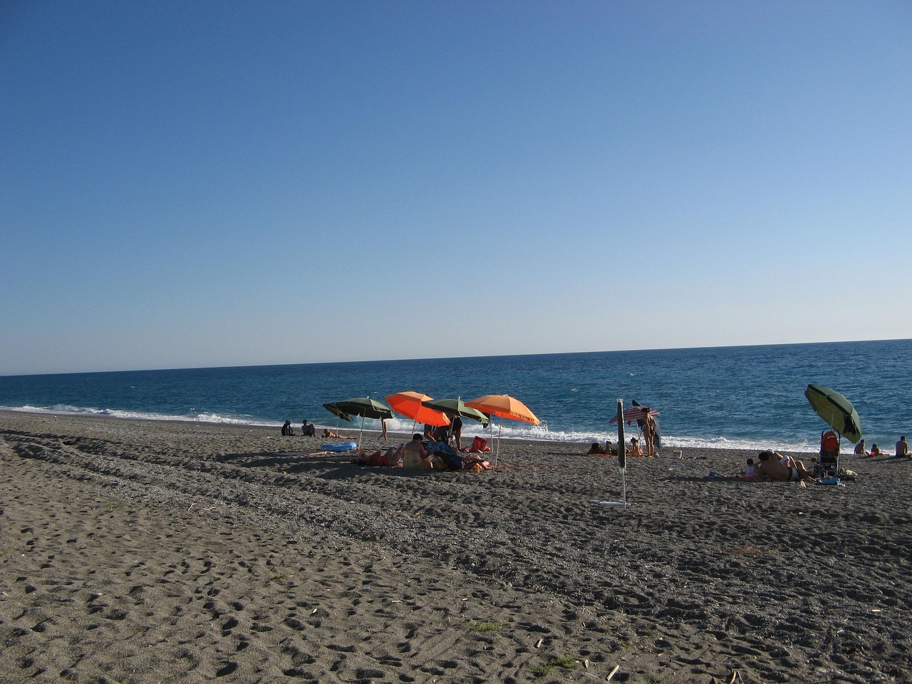 Spiaggia segreta in Liguria con acqua smeraldo, accessibile solo a piedi tra natura incontaminata.