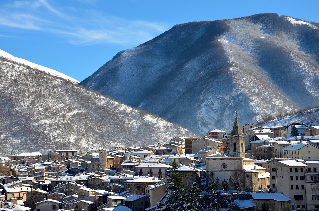 Panorama di una città italiana innevata, con luci natalizie e strade tranquille, ideale per una visita in inverno.