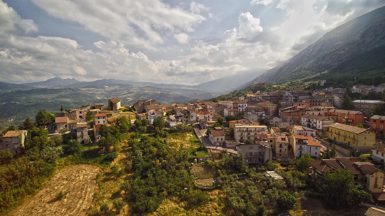 Panorama suggestivo di un piccolo paese dell'Abruzzo con montagne sullo sfondo e case tipiche in pietra.