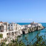 Paesaggio pittoresco di un borgo pugliese, con strade acciottolate e case bianche, rappresenta l'autenticità della Puglia.