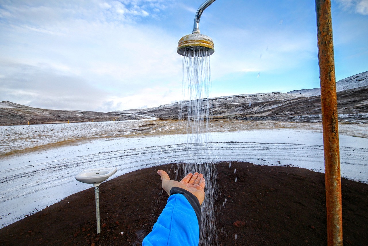 Uomo che si rilassa in una pozza termale circondata da neve in un paesaggio invernale.