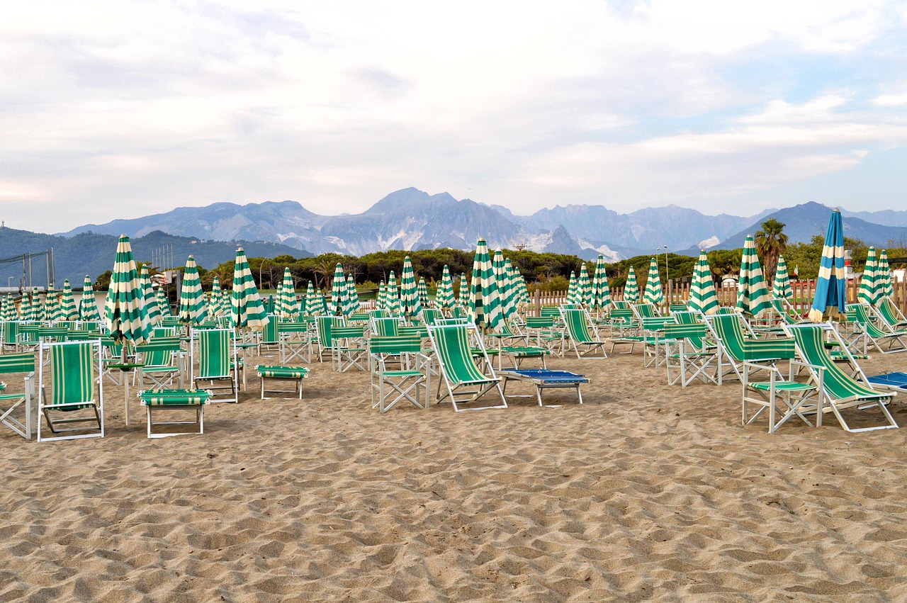 Spiaggia italiana panoramica, accessibile a piedi, con sabbia dorata e acque cristalline.