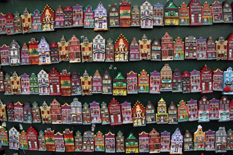 Canali di Amsterdam coperti di neve con persone che passeggiano sotto ombrelli.