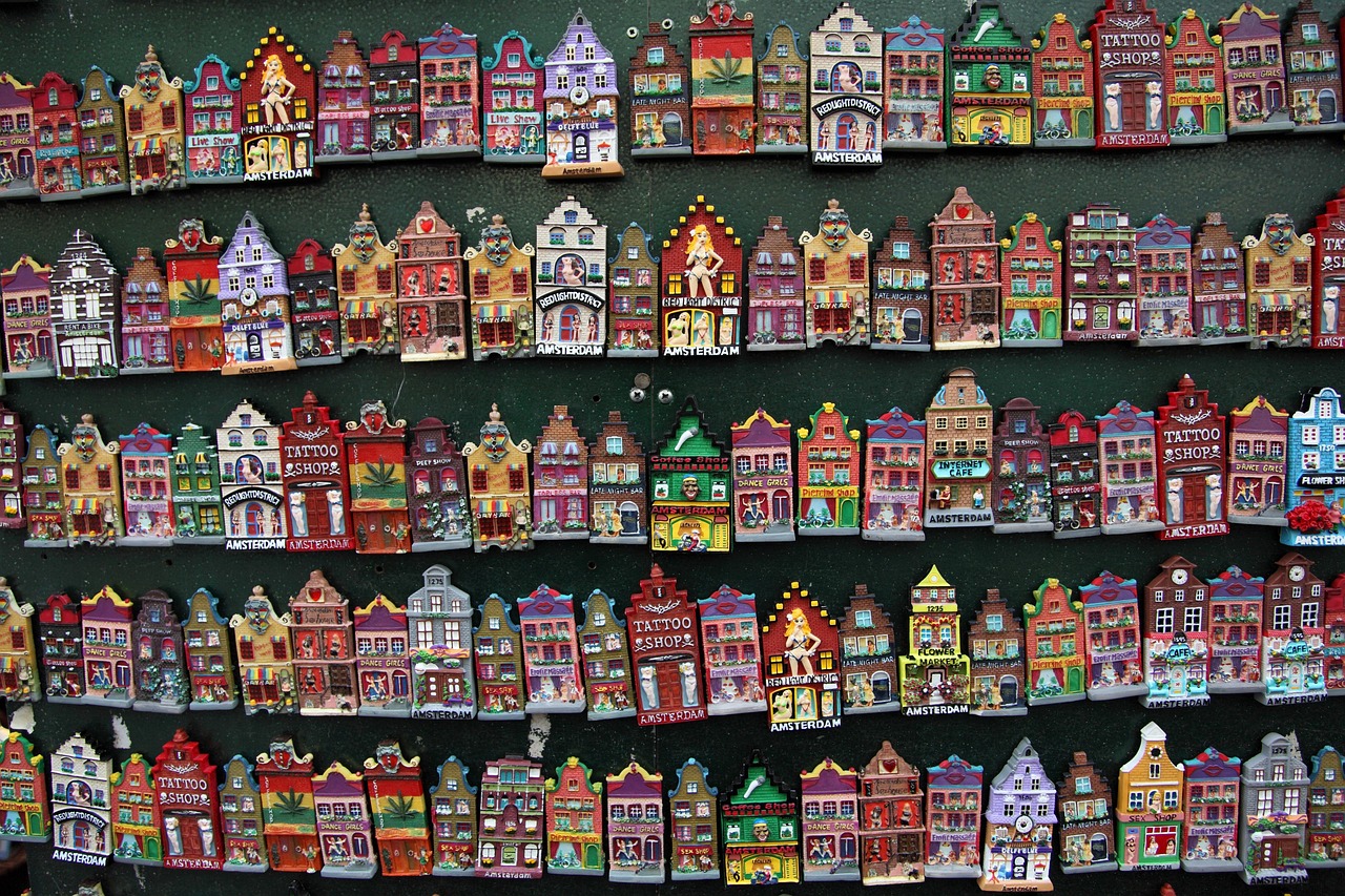 Canali di Amsterdam coperti di neve con persone che passeggiano sotto ombrelli.