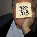 Uomo disabile in sedia a rotelle che consulta documenti sulla pensione anticipata.