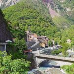 Borgo valdostano incantevole con case in pietra e paesaggio montano fiabesco.
