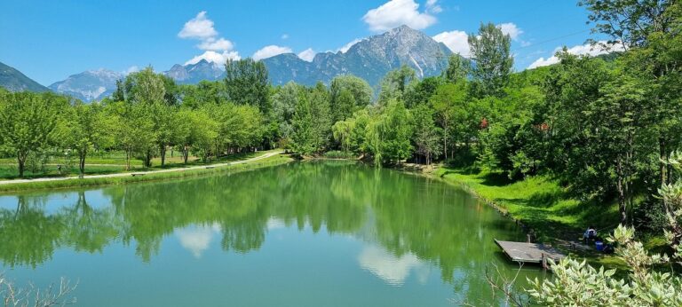 Lago di Tenno in Trentino, acque turchesi circondate da montagne e boschi.