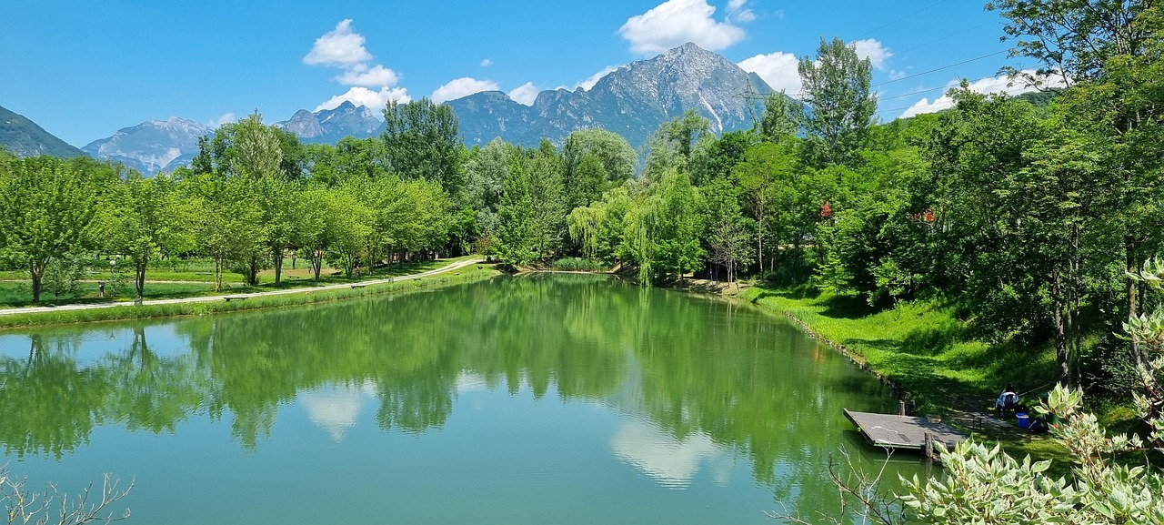 Lago di Tenno in Trentino, acque turchesi circondate da montagne e boschi.